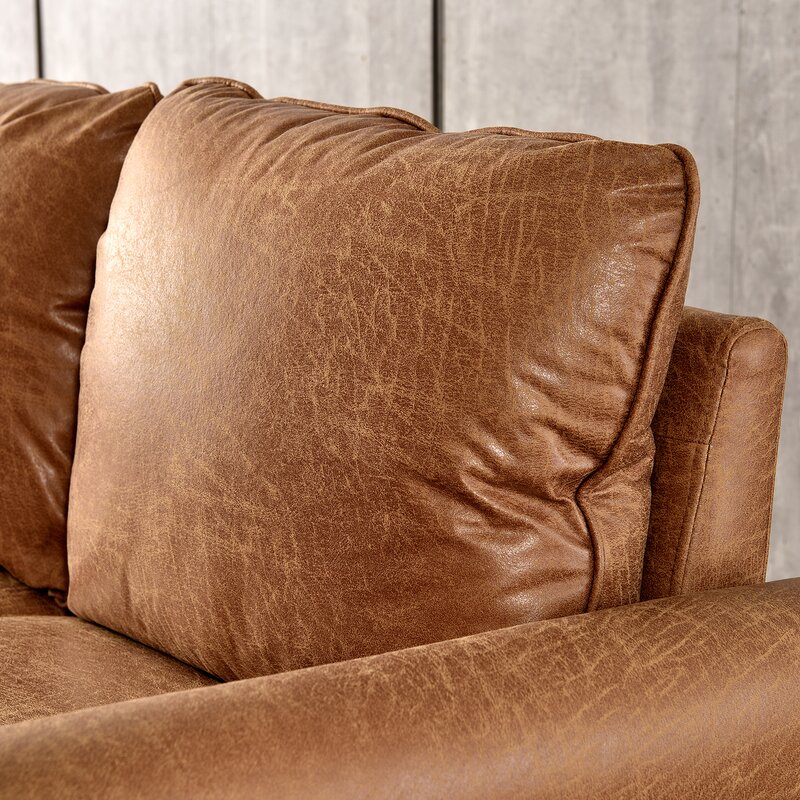 A classic sofa with rolled arms and tapered wooden legs in a neutral fabric.