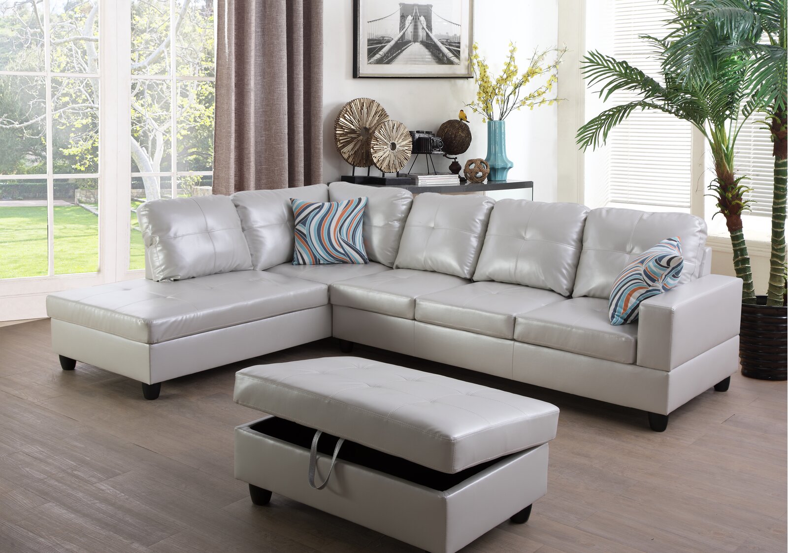 A spacious modern sofa with a chaise lounge in faux leather.