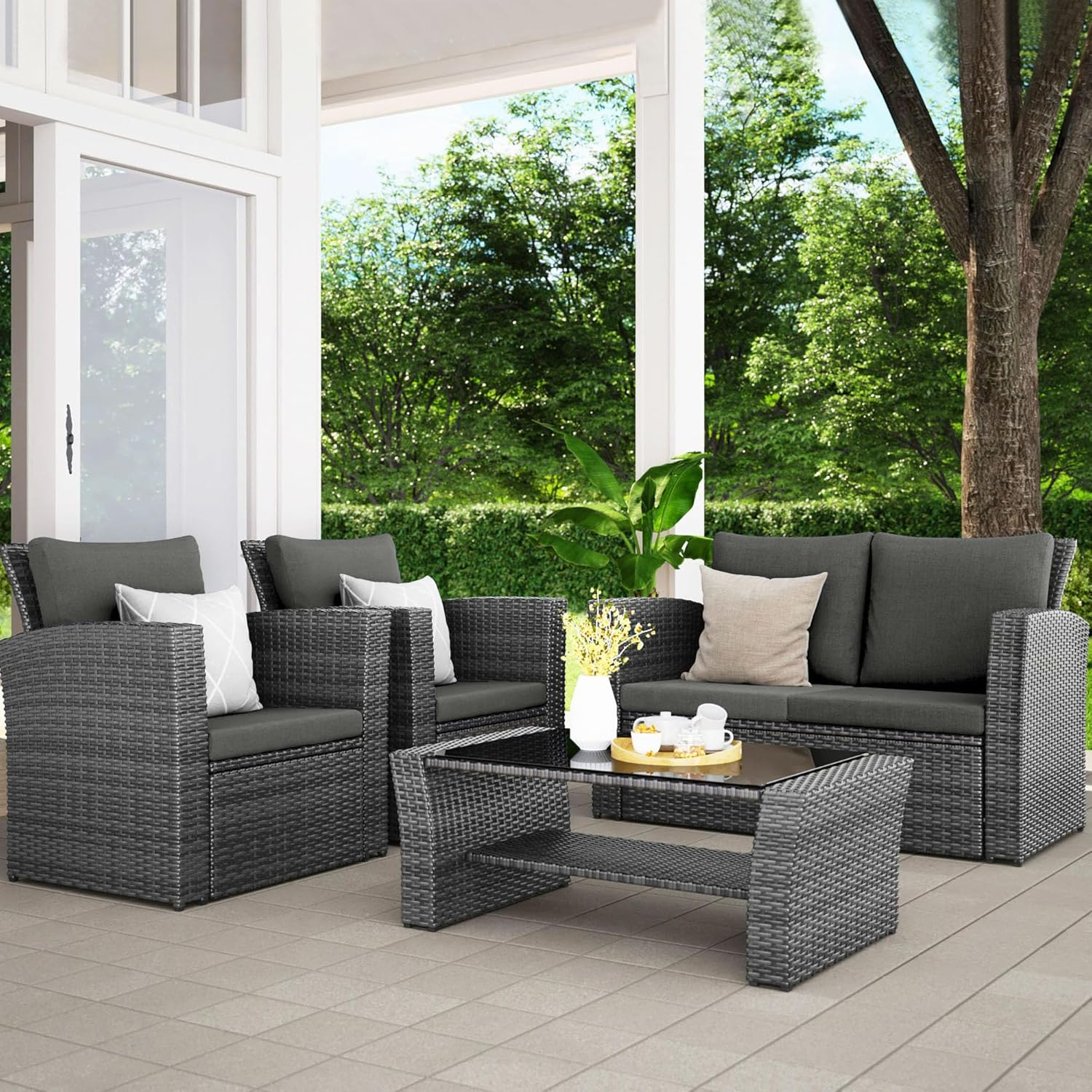 Grey rattan outdoor sofa and chairs arranged on a deck