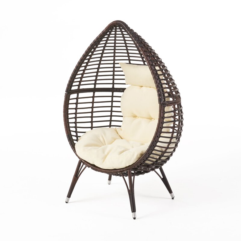 outdoor wicker armchair with beige cushions on a patio