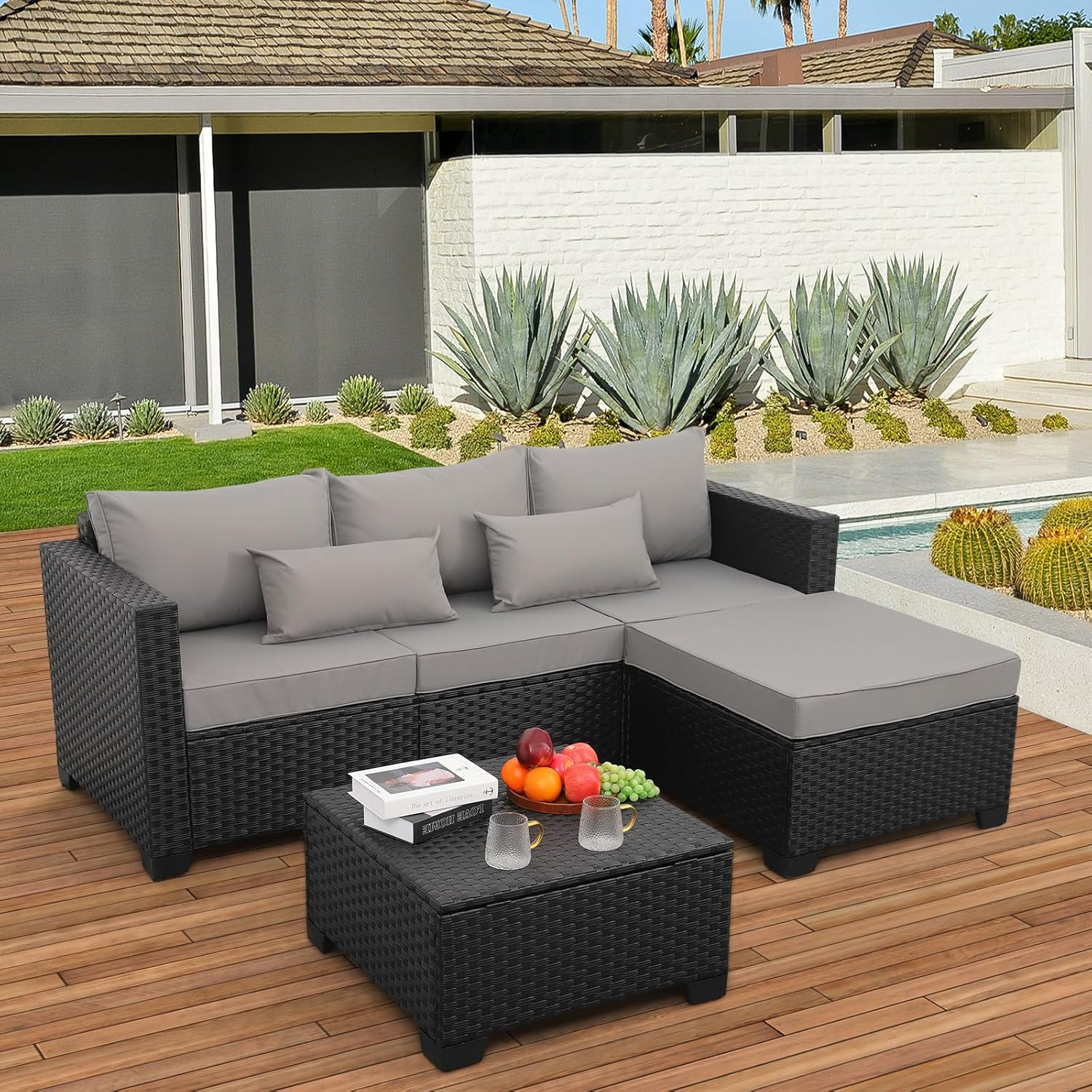 A modern black wicker outdoor sectional sofa and loveseat arranged on a patio.