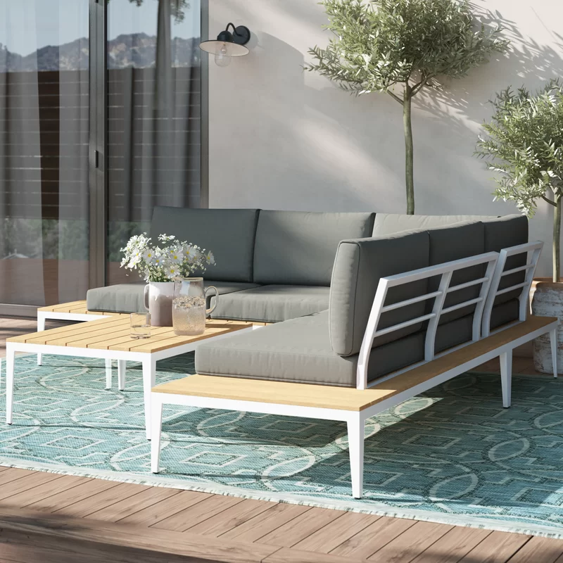 A 5-person wicker patio lounge set arranged on a stone patio.